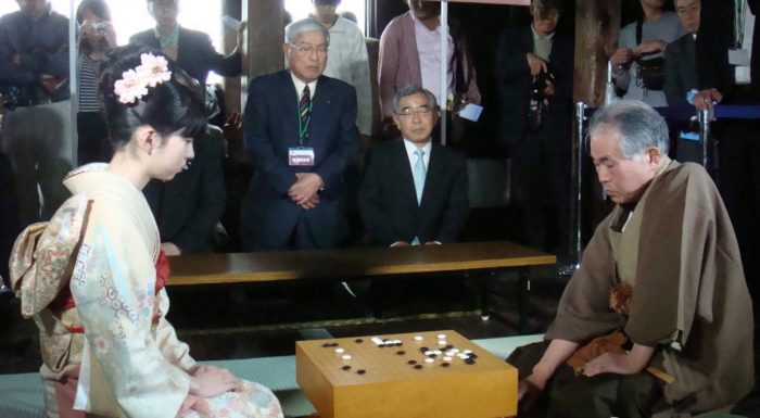 Kỳ Nhân cũ cuối cùng, Otake Hideo đang chơi cờ hướng dẫn cho một nữ sinh trong Giải vô địch Cờ vây Nghiệp dư Thế giới, lần thứ 32.